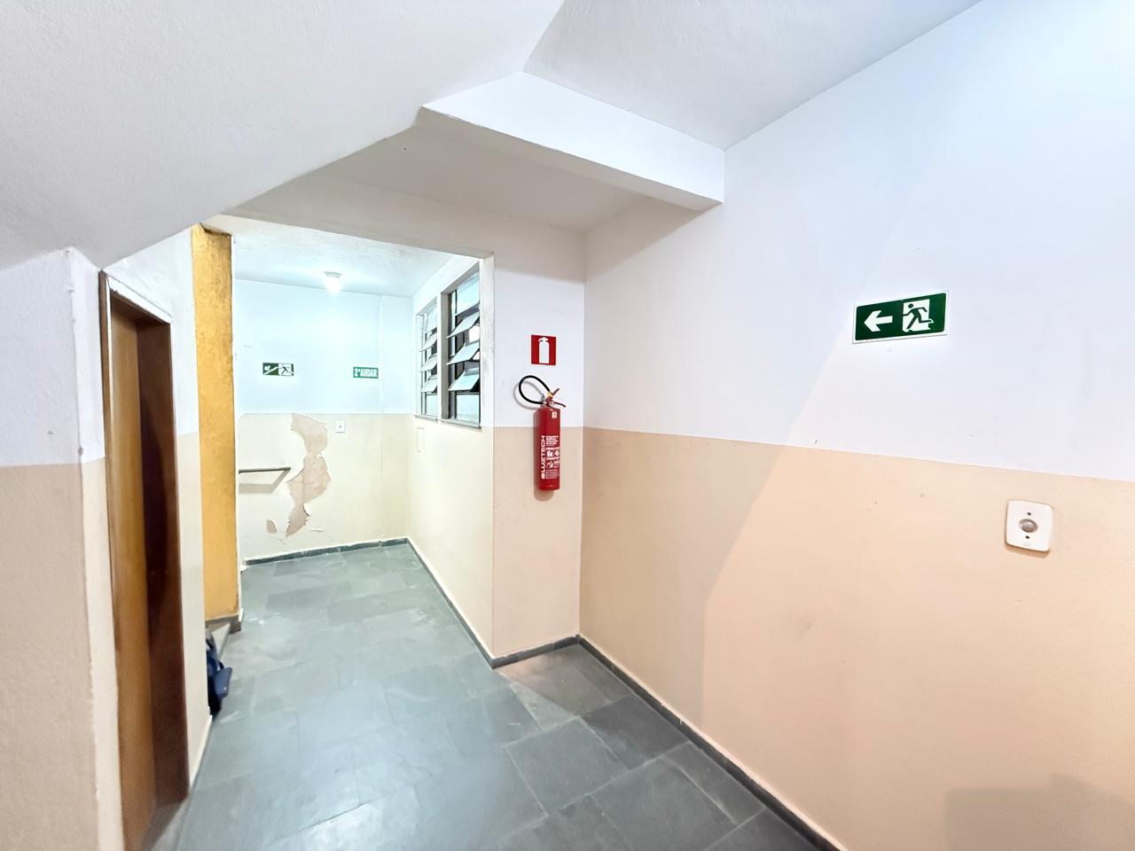 Extintor e sinalização de saída instalados em hall
