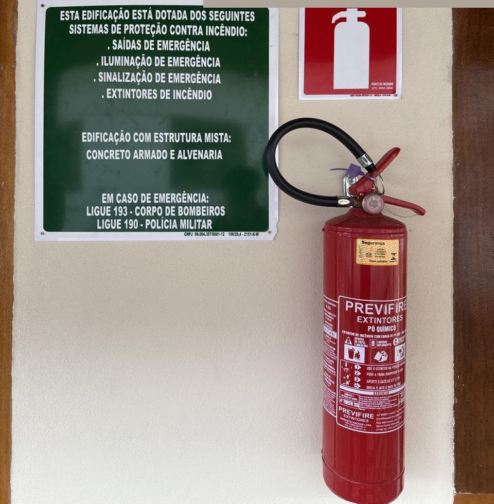 Extintor e placas de sinalização de segurança instalados